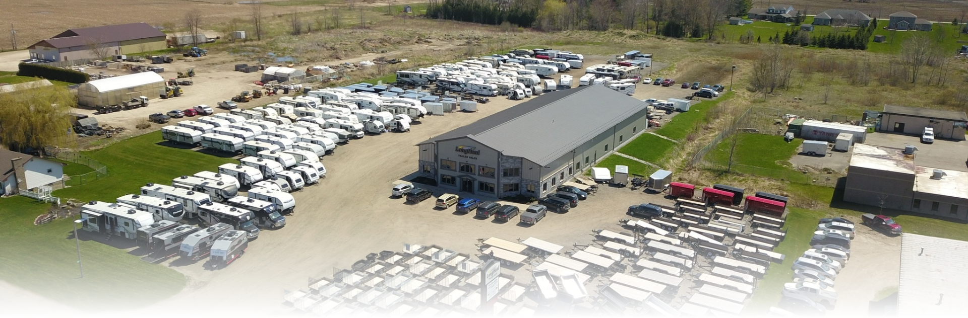 A picture of Long Haul Trailer Sales dealership. You can see a yard full of used and new rv's and trailers ready for sale. You can see the service and parts department from this ariel view.