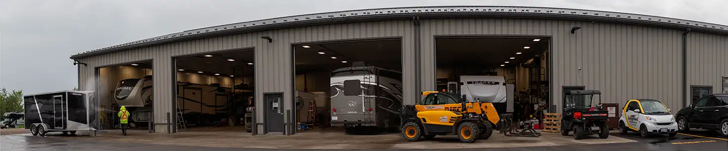 A picture of the service department. Trailers are having fiberglass fixed, winterization being done, and maintenance being preformed by mechanics.